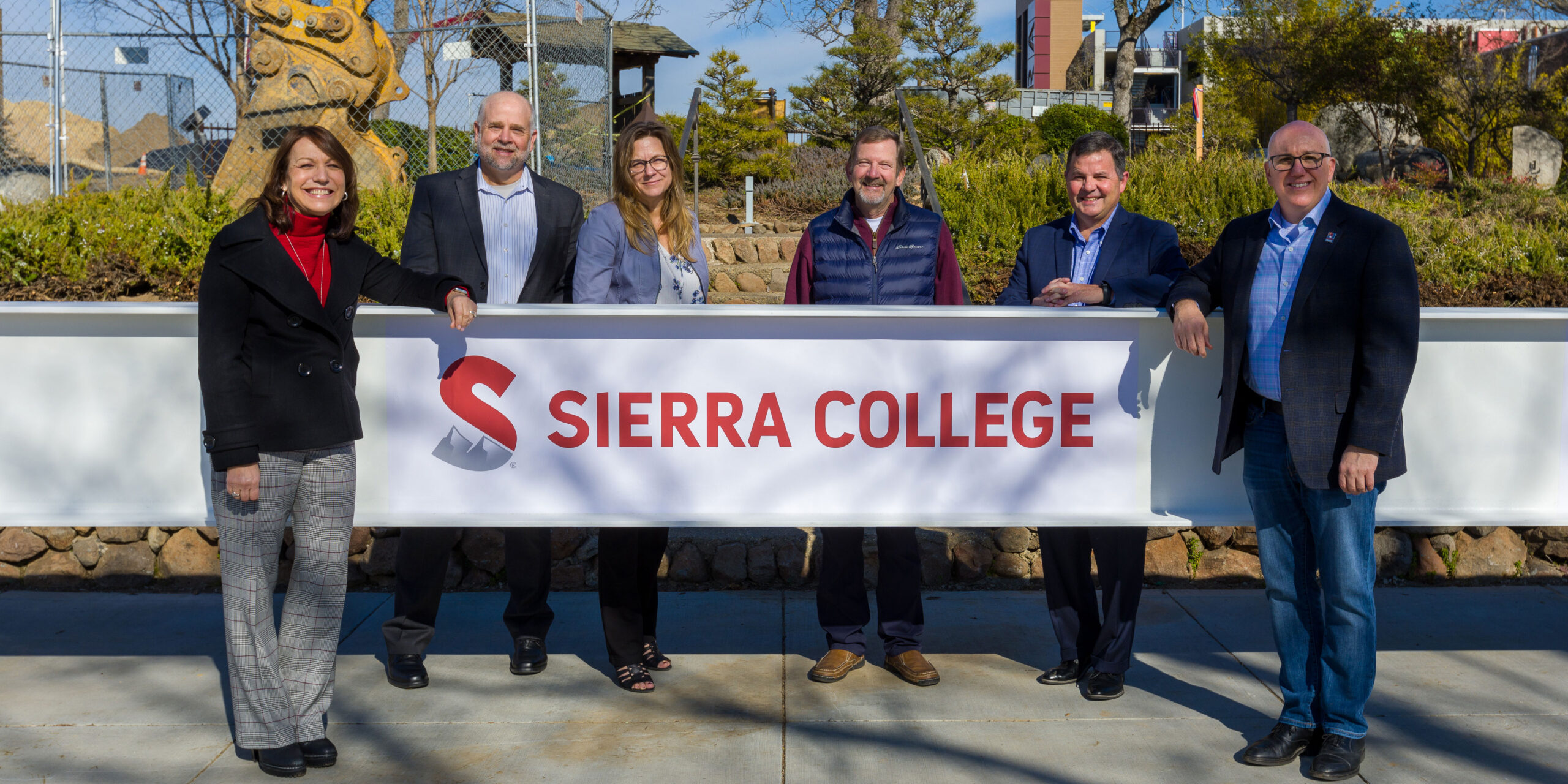 Six Sierra College executives and board members pose with the signed beam.