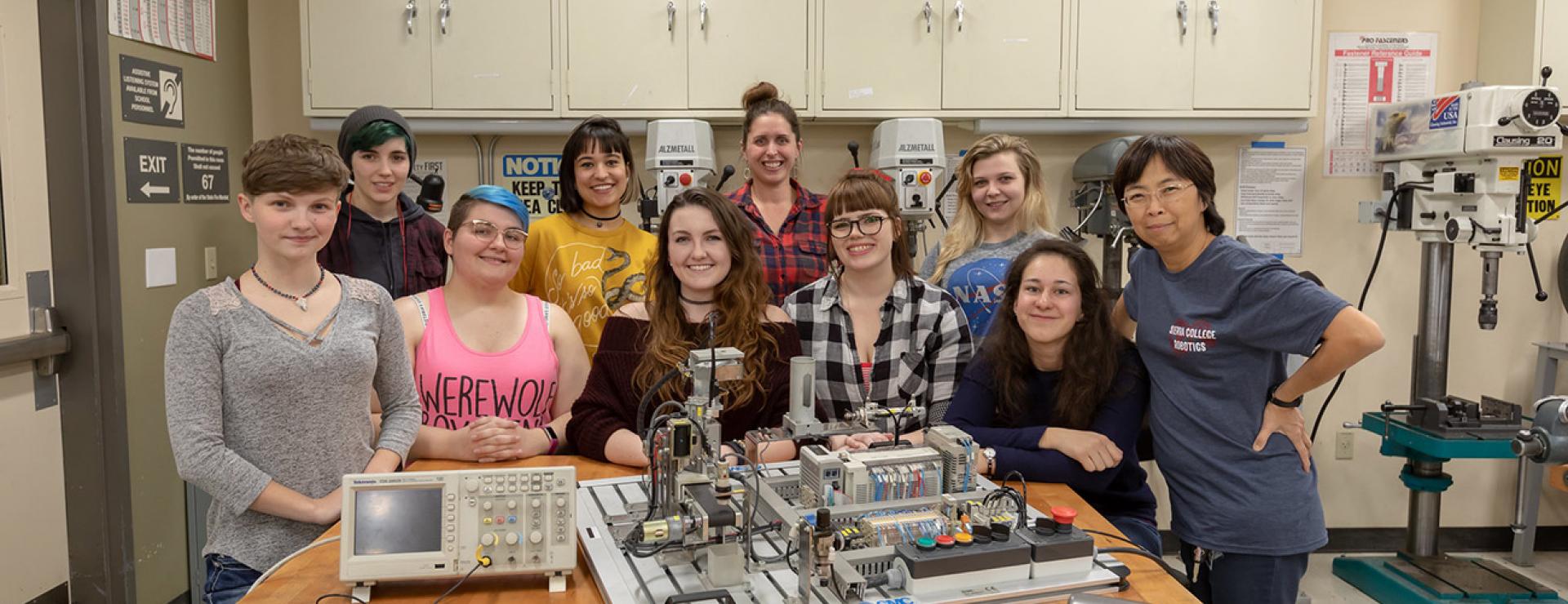 Mechatronics instructor and female students learning robotics