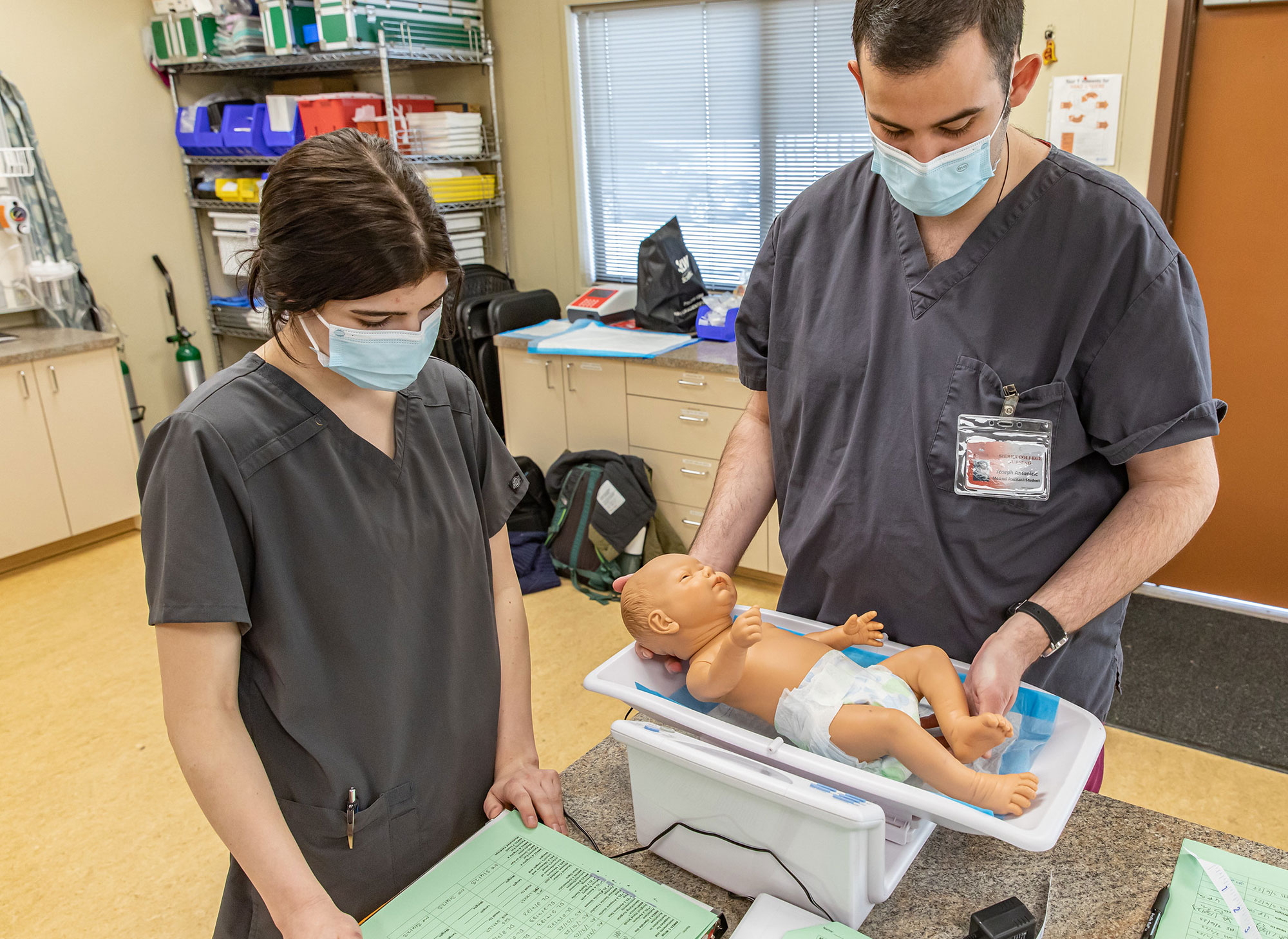 Medical Assistant students practicing tasks on simulated baby.