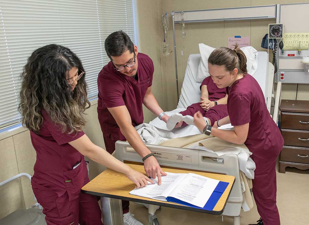 Prenursing students practice moving patient
