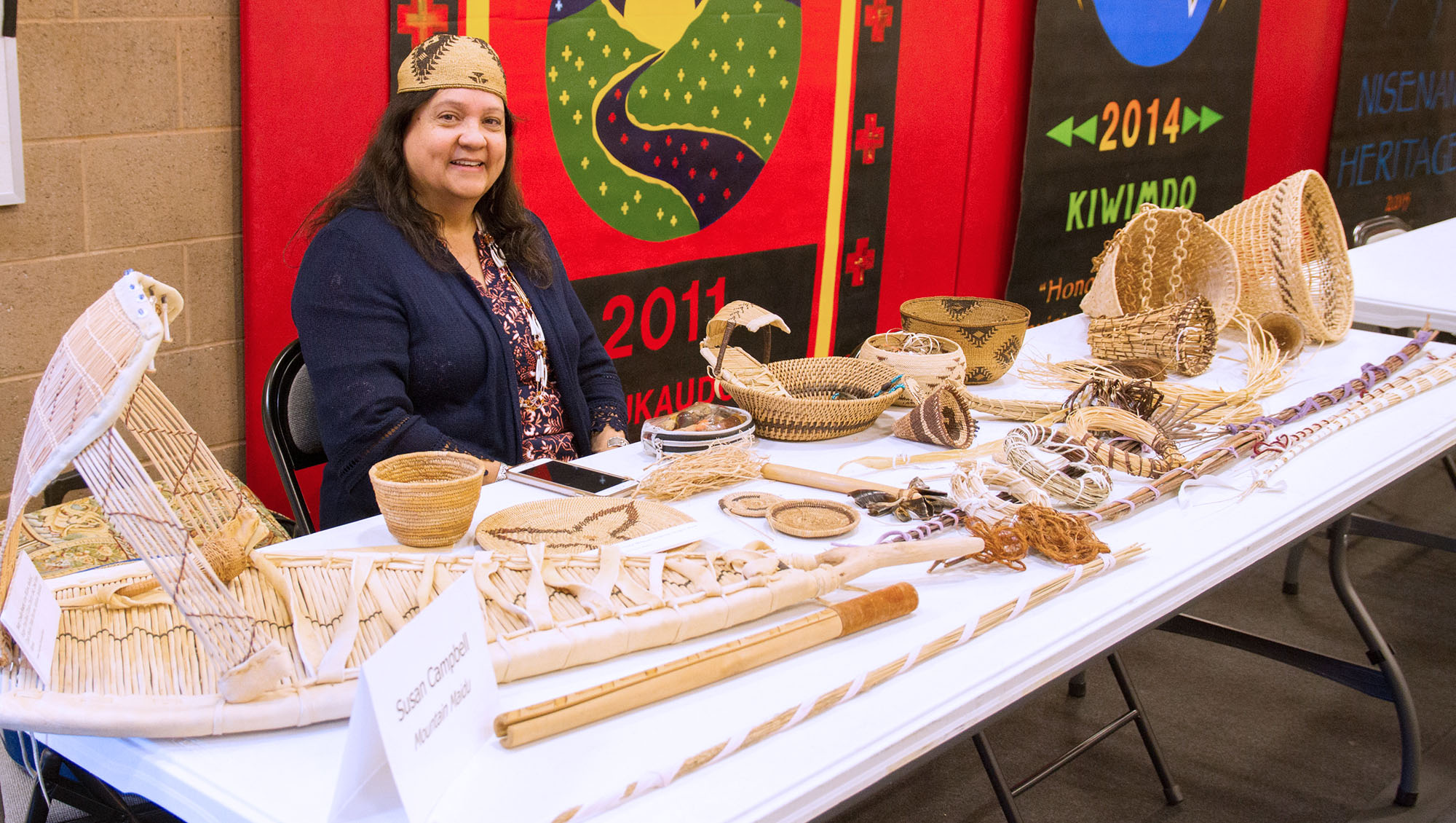 Susan Campbell of the Mountain Maidu people shows off a selection of woven baskets and items