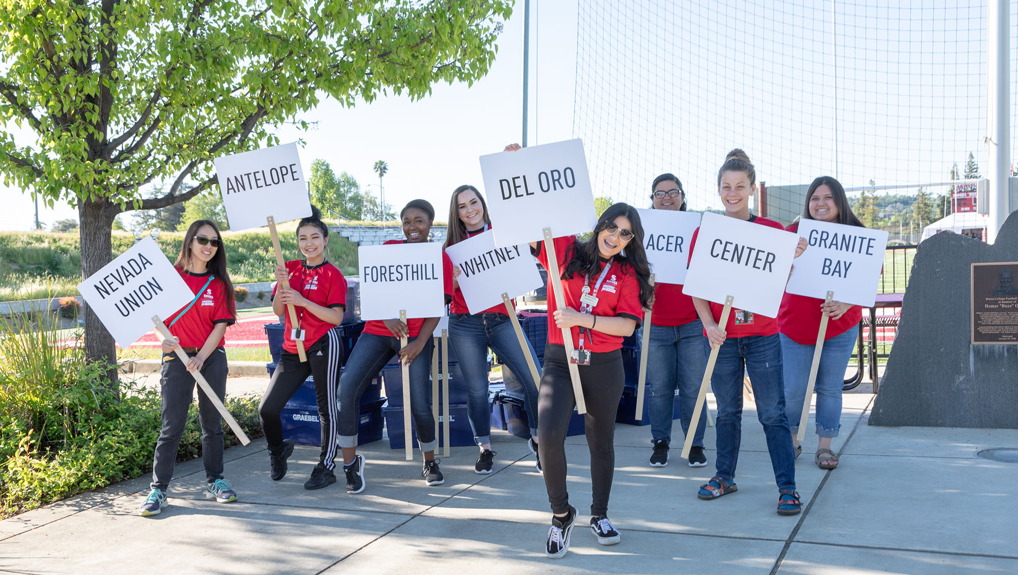 Local high school students holding signs with their high school names at a Sierra College event