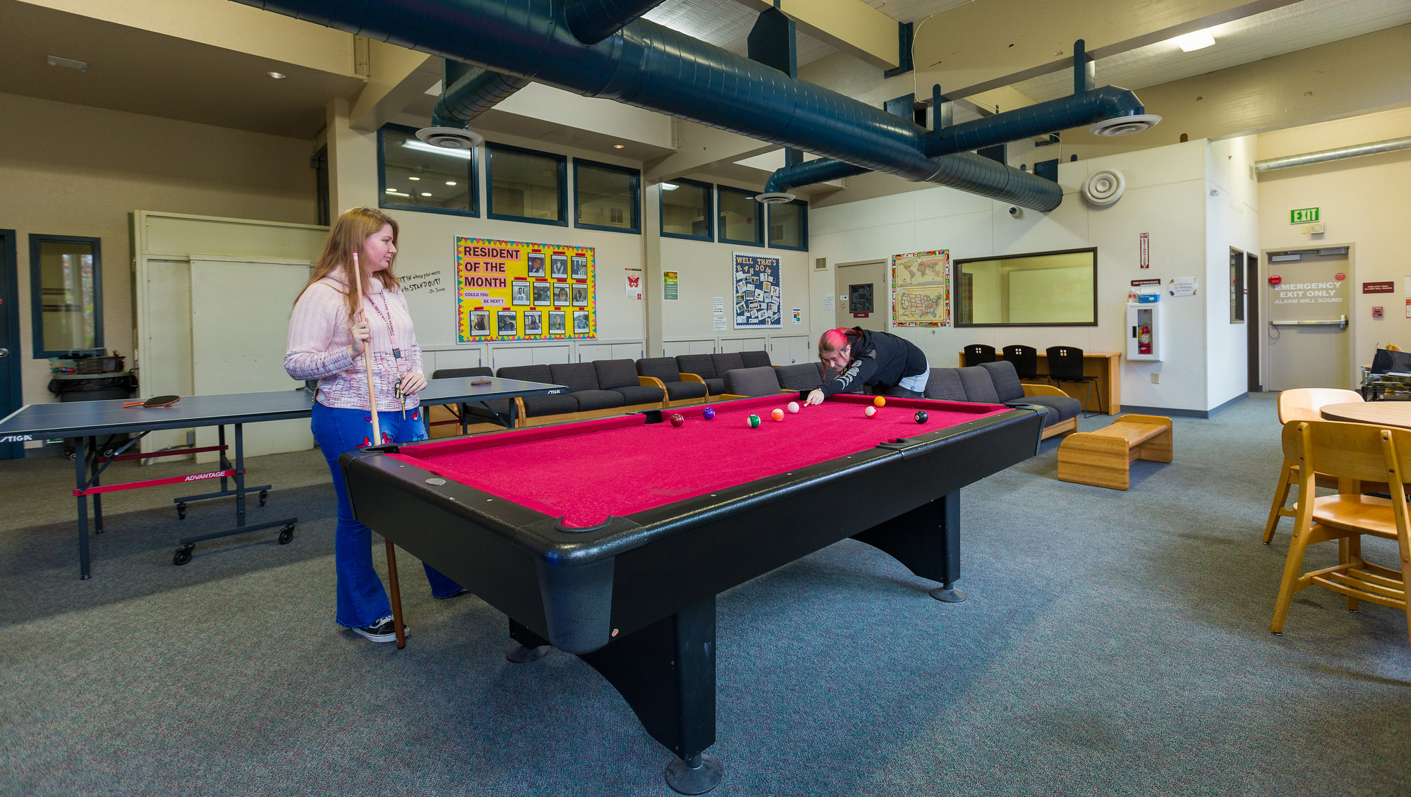 Students in recreation room playing pool