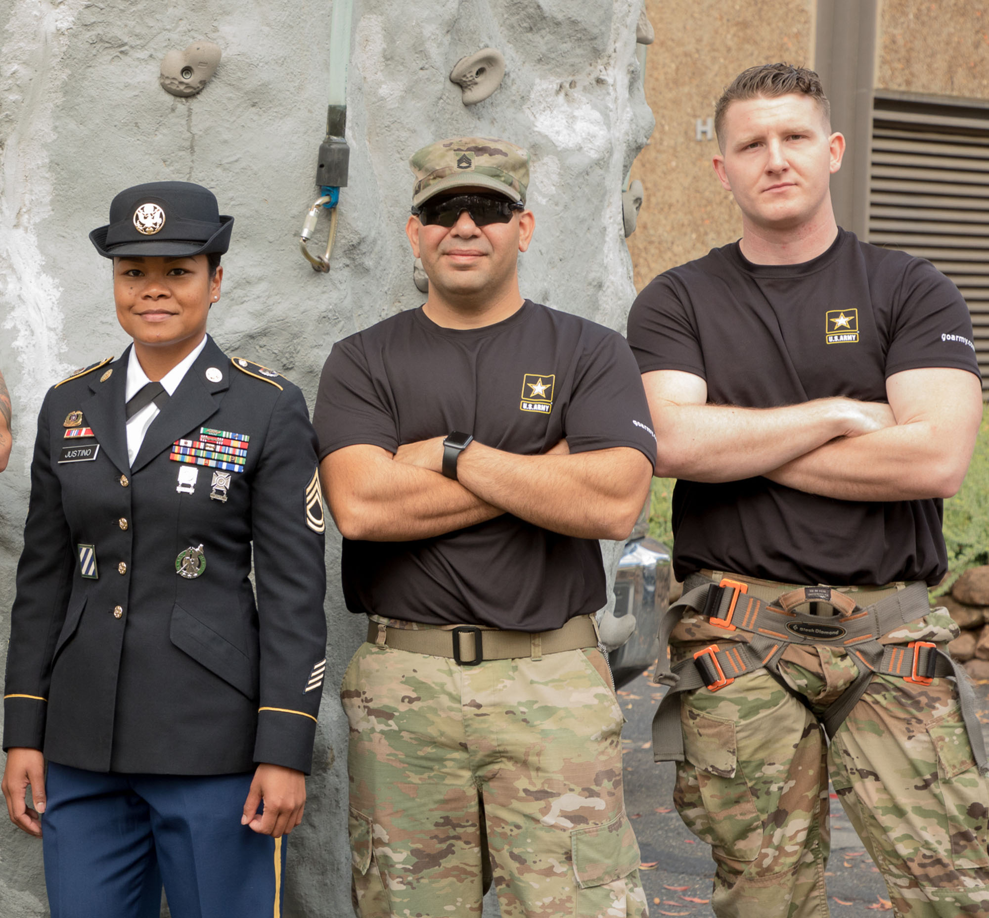 One female army officer in uniform and two male active service members in army fatigues