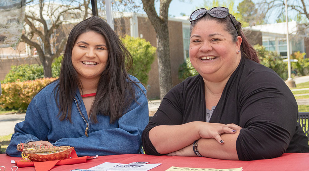 Two students at the Native American Club booth during Wolverine Week
