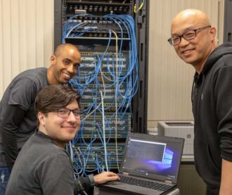 Students working on routing and switching essentials in cybersecurity class