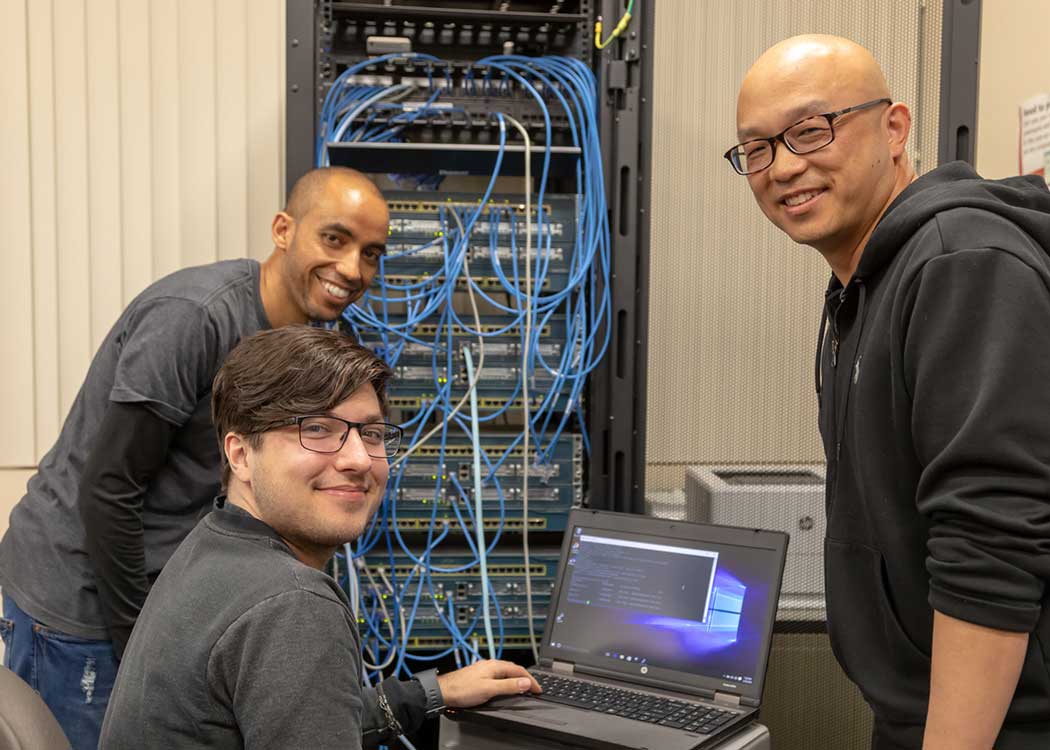 Students working on routing and switching essentials in cybersecurity class